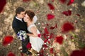 Wedding couple under a rain of rose petals. Royalty Free Stock Photo