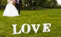 Wedding couple unfocused and love word on the grass Royalty Free Stock Photo