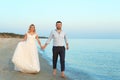 Wedding couple walking on beach. Royalty Free Stock Photo