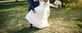 Wedding couple walking in the green park. Curvy bride in white lace dress and groom are holding hands. Overweight happy people. Royalty Free Stock Photo