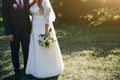 Wedding couple walking in the green park. Curvy bride in white lace dress and groom are holding hands. Overweight happy people. Royalty Free Stock Photo