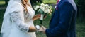 Wedding couple walking in the green park. Curvy bride in white lace dress and groom are holding hands. Overweight happy people. Royalty Free Stock Photo