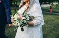 Wedding couple walking in the green park. Curvy bride in white lace dress and groom are holding hands. Overweight happy people. Royalty Free Stock Photo