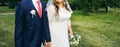 Wedding couple walking in the green park. Curvy bride in white lace dress and groom are holding hands. Overweight happy people. Royalty Free Stock Photo