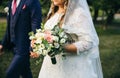 Wedding couple walking in the green park. Curvy bride in white lace dress and groom are holding hands. Overweight happy people. Royalty Free Stock Photo