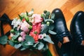 Wedding day accessories. Groom`s shoes with bouquet on the wooden background. Golden rings and bow tie are nearby. Stylish things Royalty Free Stock Photo