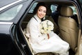 Wedding Day: beautiful bride with bouquet of white flowers in the car Royalty Free Stock Photo