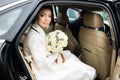 Wedding Day: beautiful bride with bouquet of white flowers in the car Royalty Free Stock Photo