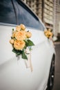 Wedding decor on the car handle. Flower decoration with ribbons on a white car Royalty Free Stock Photo