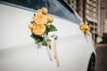 Wedding decor on the car handle. Flower decoration with ribbons on a white car Royalty Free Stock Photo