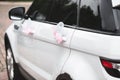 Wedding decor on the car handle. Flower decoration with ribbons on a white car Royalty Free Stock Photo