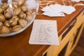 Golden walnut in a glass round vase and a guest seating list. Wedding decor