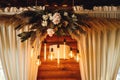 Wedding decor in hall with floral arrangement and Edison lamps