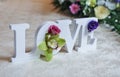 Wedding decor, LOVE letters and flowers on table. Fresh flowers and LOVE decoration on festive table. Luxurious wedding decoration