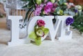 Wedding decor, LOVE letters and flowers on table. Fresh flowers and LOVE decoration on festive table. Luxurious wedding decoration Royalty Free Stock Photo