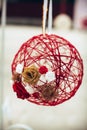 Wedding decor, a red ball glued from threads and flowers in beige, white and red, at a banquet Royalty Free Stock Photo