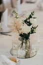 Wedding decor. A yellow rose stands on a table with greenery and candles