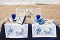 Wedding decoration in a marine style - table for the bride and groom on a sandy beach decorated with sea shells, corals