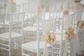 Wedding decorations flowers on chairs. Wedding exit registration, white chairs decorated for wedding. wedding setup
