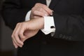 Wedding details, cufflinks, elegant male suit and hands