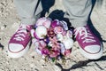 Wedding details in the form of purple sneakers and a purple wedding bouquet. Royalty Free Stock Photo