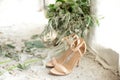 Wedding details, green bridal bouquet, shoes on a concrete window-sill of a pan-window.