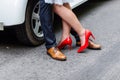 Wedding details: stylish red and brown shoes of bride and groom. Newlyweds standing in front of each other near the car Royalty Free Stock Photo