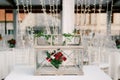 Wedding dinner table reception. Decoration of the table - a wooden box with glass, with a bouquet of flowers inside of Royalty Free Stock Photo