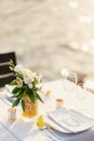 Wedding dinner table reception. Glass transparent bath with sliced lemons and a bouquet of white Alstromeri, on the Royalty Free Stock Photo