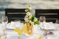 Wedding dinner table reception. Glass transparent bath with sliced lemons and a bouquet of white Alstromeri, on the Royalty Free Stock Photo