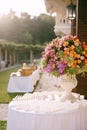 Wedding dinner table reception. A huge bouquet in an old marble vase of pink, red, orange and yellow roses, green Royalty Free Stock Photo