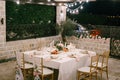 Wedding dinner table reception. Rectangular table for six people with a white tablecloth and pink napkins. The golden