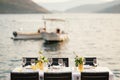 Wedding dinner table reception. Rectangular tables with white tablecloth, floral arrangements lemons in vases. Yellow