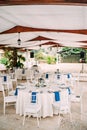 Wedding dinner table reception. Round banquet table with white tablecloth and white Chiavari chairs. Wedding under the