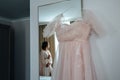 Wedding dress and bride looking on it in the reflection of the mirror Royalty Free Stock Photo