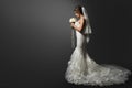 Wedding Dress. Bride in white Gown. Bridal Fashion Model holding Flower Bouquet. Profile View over Black Background. Copy space Royalty Free Stock Photo