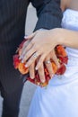 Bride and grooms hands, rings and bouquet. Royalty Free Stock Photo