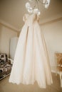 Wedding dress on hanger in the bride room. On her wedding day
