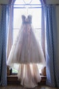 Wedding dress hanging awaiting the bride. Royalty Free Stock Photo