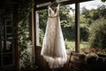 A Wedding Dress Hanging On A Hanger In A Quaint Farmhouse With A Charming Garden And Countryside Views. Generative AI
