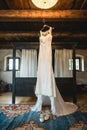 Wedding dress hanging in a rustical hotel room