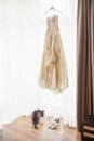 Wedding dress hanging by the window Royalty Free Stock Photo