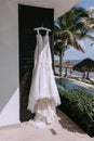 A wedding dress hangs on a hanger in a hotel near the ocean Royalty Free Stock Photo