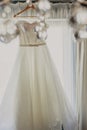 Wedding dress. White wedding dress with a full skirt on a hanger in the room of the bride with white curtains. Wedding Royalty Free Stock Photo