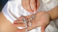 Wedding earrings on a bridal hand, bride`s morning and jewelry accessories and decoration concept. Girl hold earrings