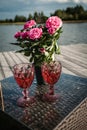 Wedding festive composition of a bouquet of pink flowers in a vase and wine in glasses on the table Royalty Free Stock Photo