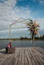 Wedding festive metal arch with fresh flowers in the Art Deco style for the newlyweds on the river bank