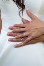 Wedding finger rings on bride groom hands on white dress background Royalty Free Stock Photo