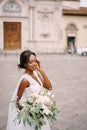 Wedding in Florence, Italy. African-American bride in a white dress and a long veil. With a magnificent bouquet of the