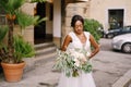 Wedding in Florence, Italy. African-American bride in a white dress and a long veil. With a magnificent bouquet of the